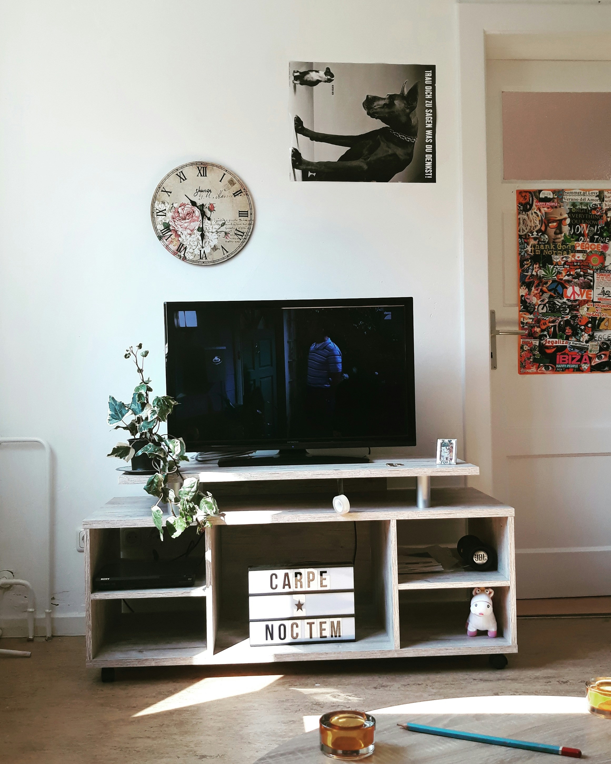 un salon avec une télévision et une horloge au mur