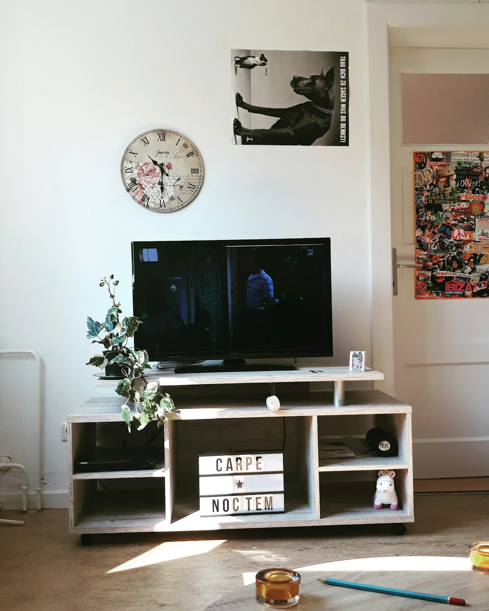 a living room with a tv and a clock on the wall