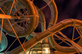 An aerial view of a sleek pneumatic tube system running through a gated society at sunset.