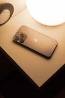 A sleek, compact smart lamp glowing warmly on a bedside table.