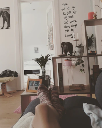 a person's feet resting on a couch in a living room