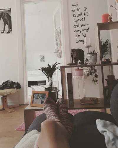 a person's feet resting on a couch in a living room