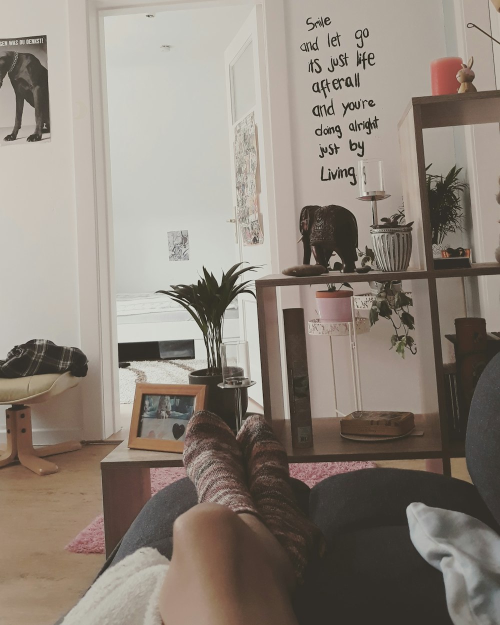 a person's feet resting on a couch in a living room
