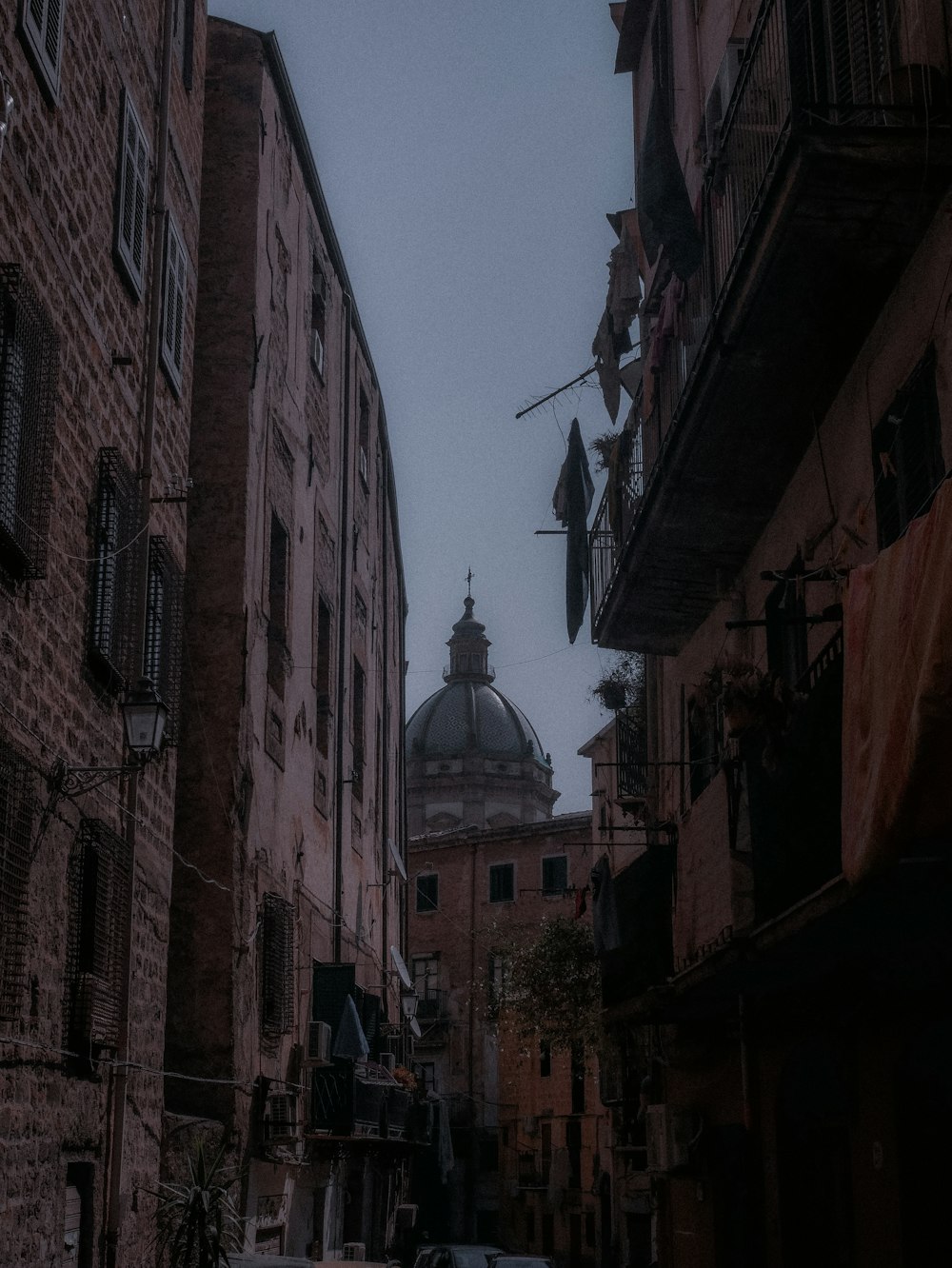 a dark alley with a clock tower in the background