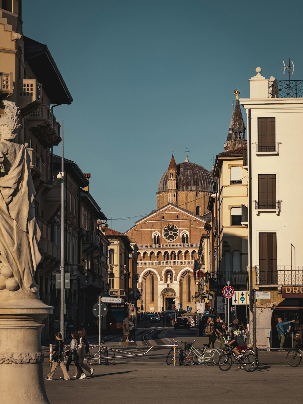 a city street with a statue of a woman on the corner