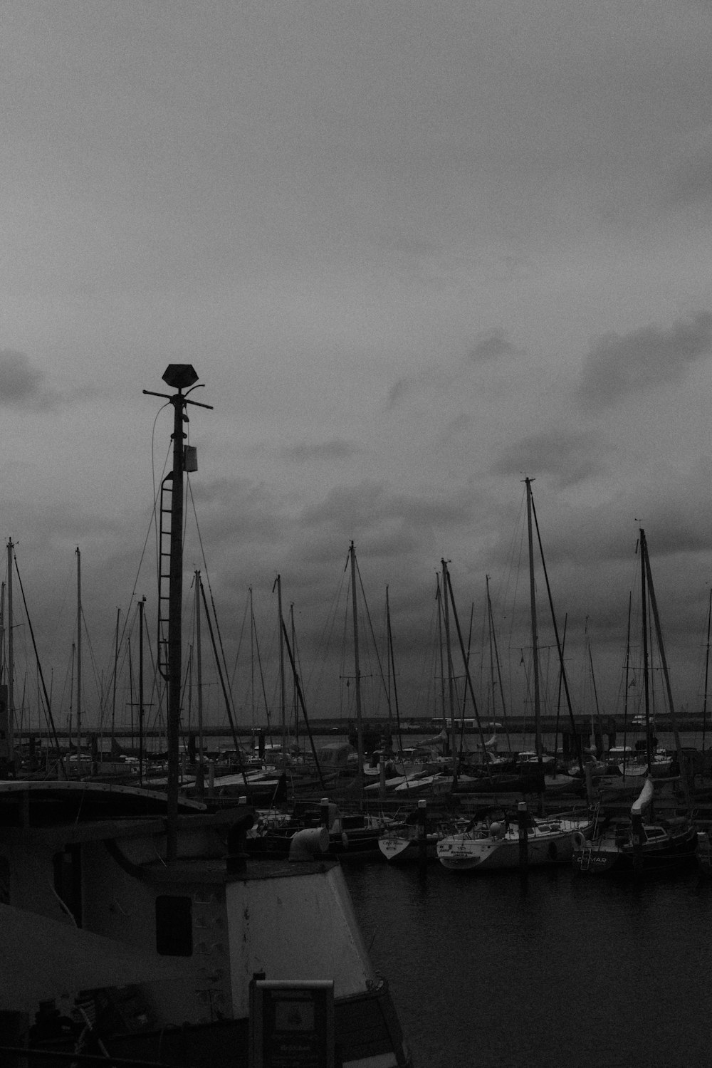 um porto cheio de barcos sob um céu nublado