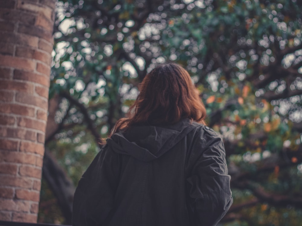 a woman standing in front of a tree