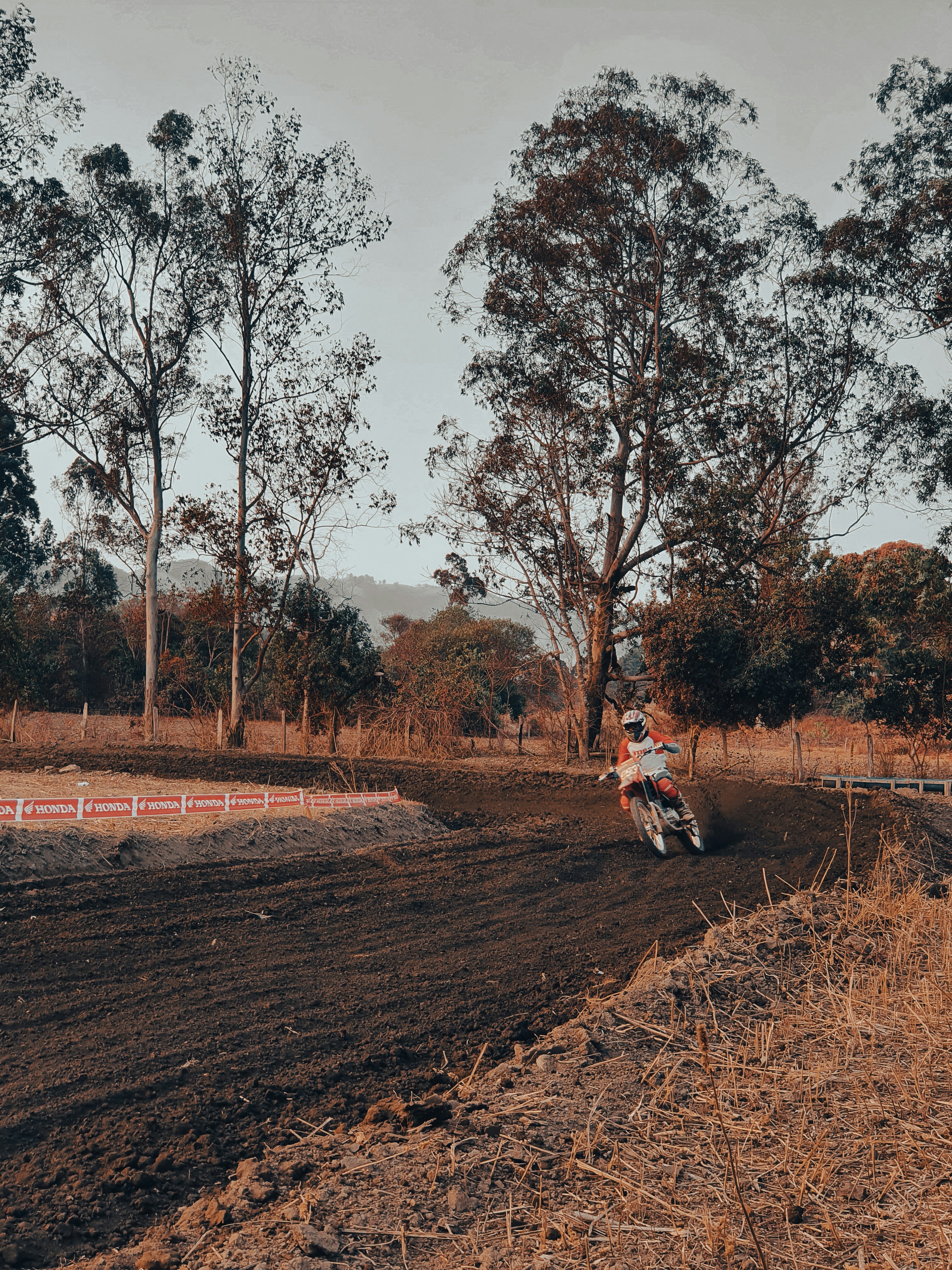 une personne conduisant une moto hors route sur un chemin de terre