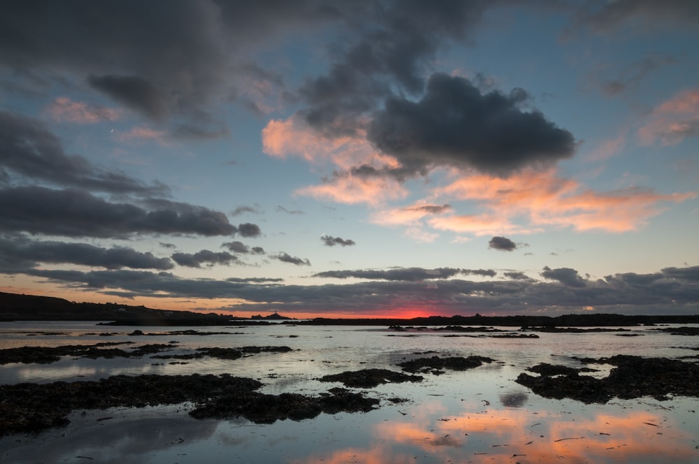 the sun is setting over a body of water