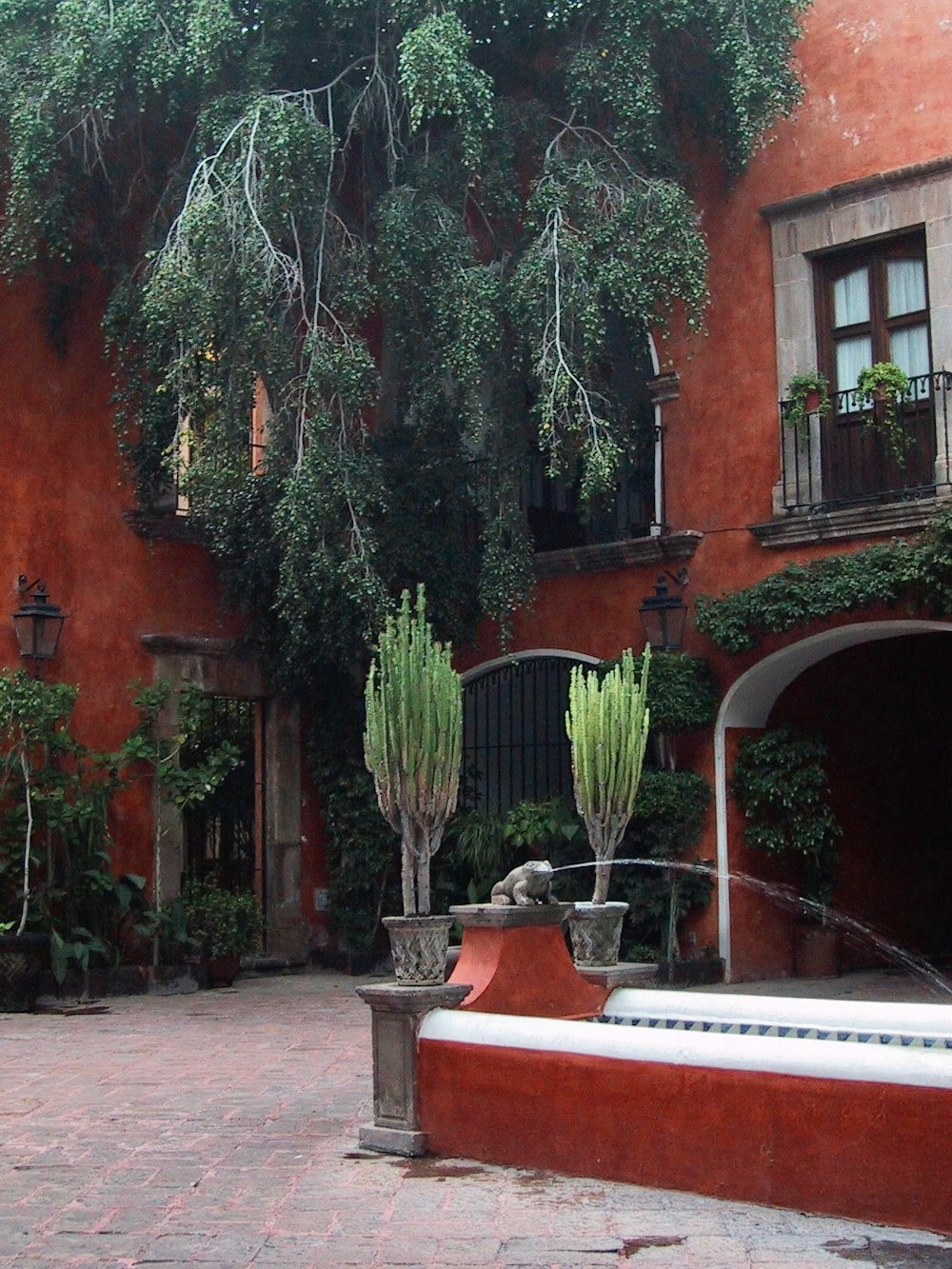 a courtyard with a bench and potted plants