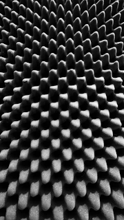 A close-up of an acoustic panel with a textured fabric cover.