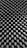 A close-up of a textured surface with a repeating pattern of peaks and valleys, resembling an acoustic foam panel. The surface has a monochrome appearance, showcasing a play of light and shadow across the geometric shapes.