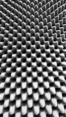 A textured surface with an intricate pattern of uniform, raised bumps and grooves, creating a three-dimensional effect.