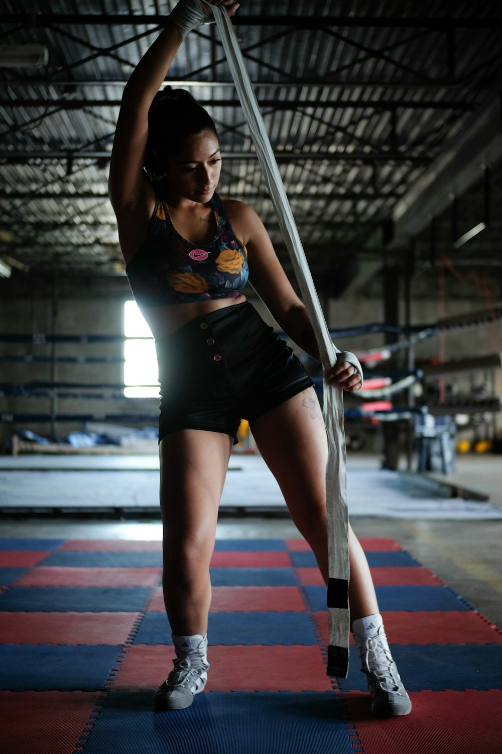 a woman holding a pole in a gym