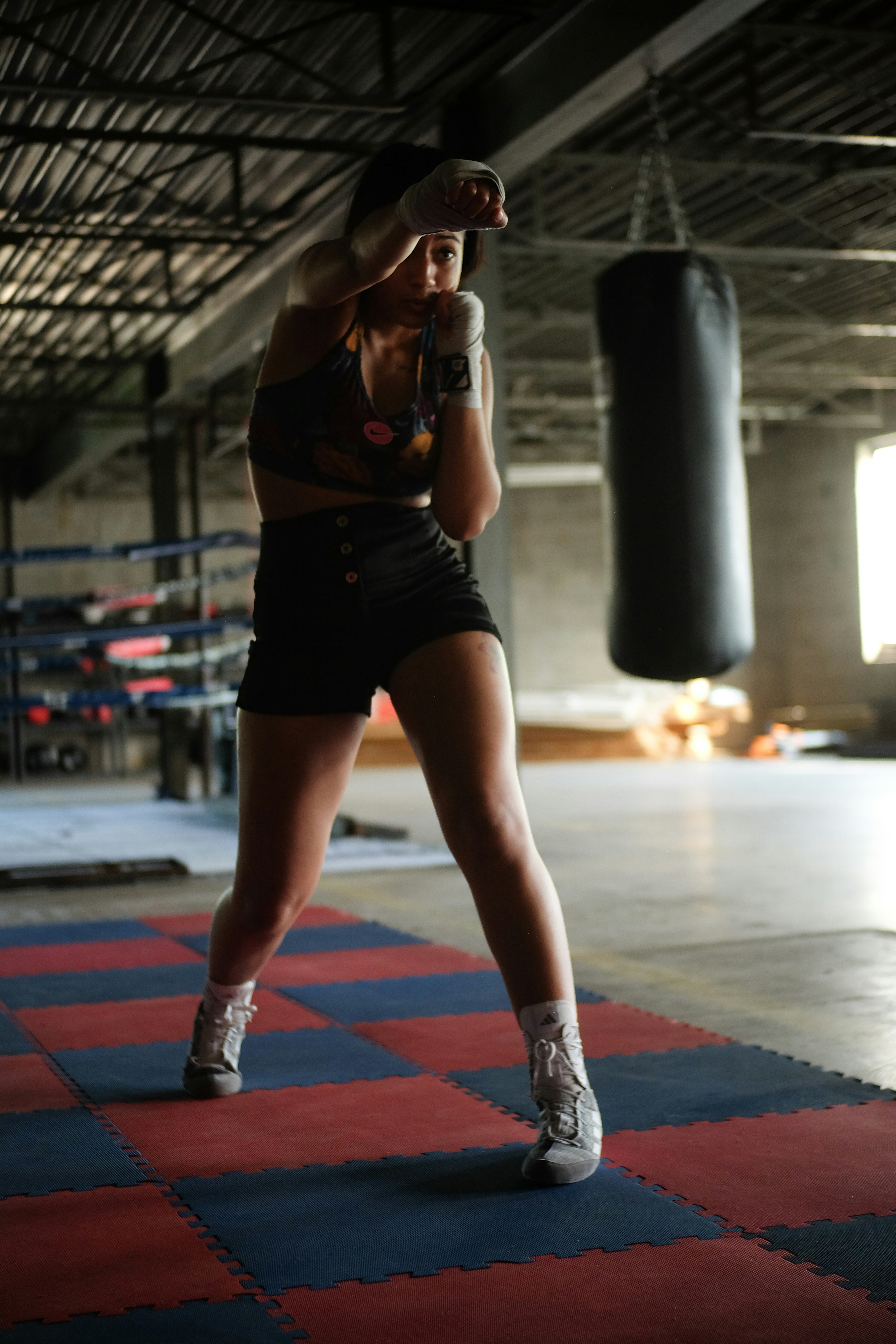 a woman standing on a mat in a gym