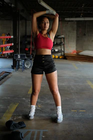 Athlete wearing sleek black and red gym wear stretching before workout in a modern gym