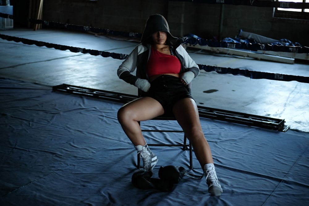 a woman sitting on a chair in a boxing ring