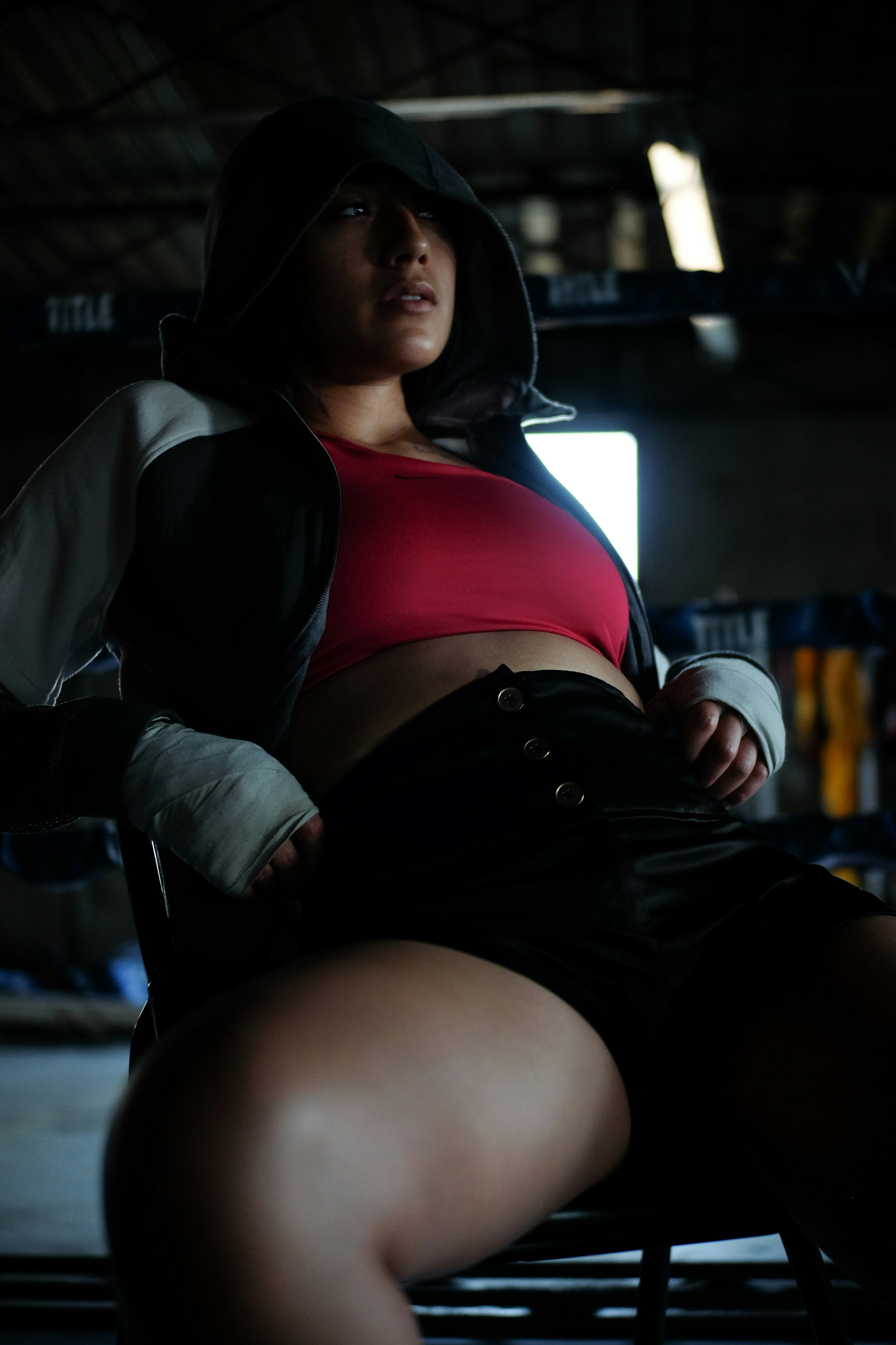 a woman sitting in a chair with a hoodie on