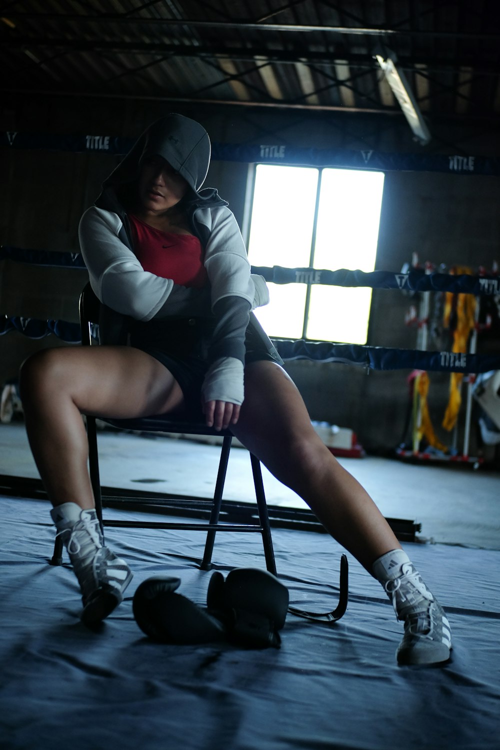 a woman sitting on a chair in a boxing ring