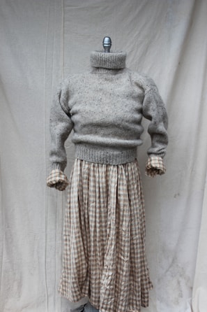 A cozy sweater displayed on a mannequin highlighting its proportions.