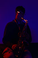 A moody, atmospheric photo of a jazz saxophonist playing live on stage