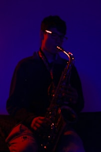 A smoky stage bathed in blue and purple lights with a saxophonist lost in the music.