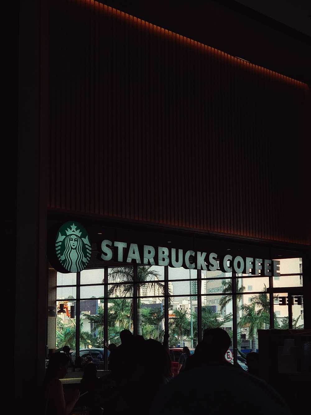 a starbucks sign is lit up in the dark