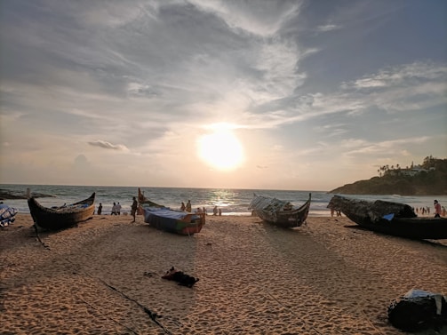 A serene beach in Goa with traditional fishing boats at sunset.