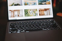 Close-up of hands uploading photos on a laptop with a blurred background.