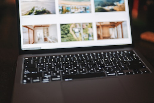 A close-up of a laptop displaying a digital portfolio with various project thumbnails.