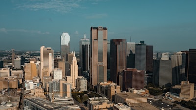 Aerial view of a modern city skyline with diverse business districts under clear sky.