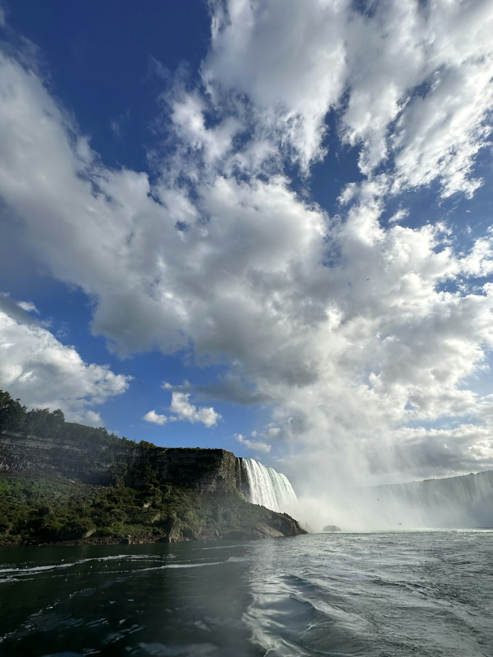 a large waterfall in the middle of a body of water