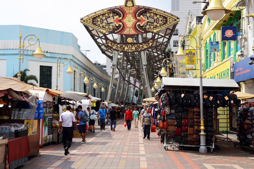 a group of people walking down a street next to shops