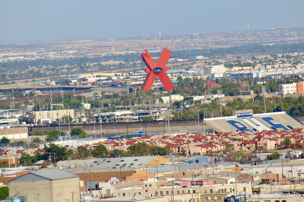 Une grande sculpture rouge est au milieu d’une ville