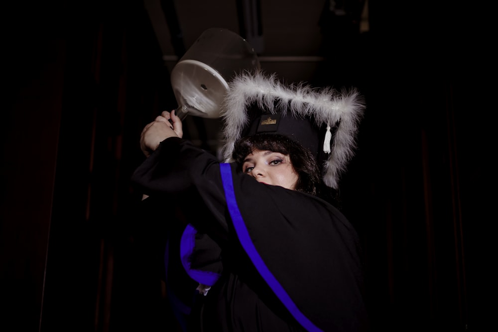 a woman in a graduation gown is holding a frisbee