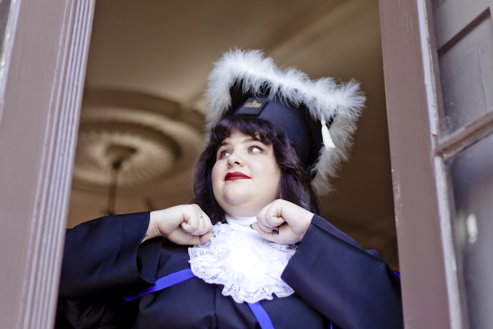 a woman in a graduation gown looking out a window