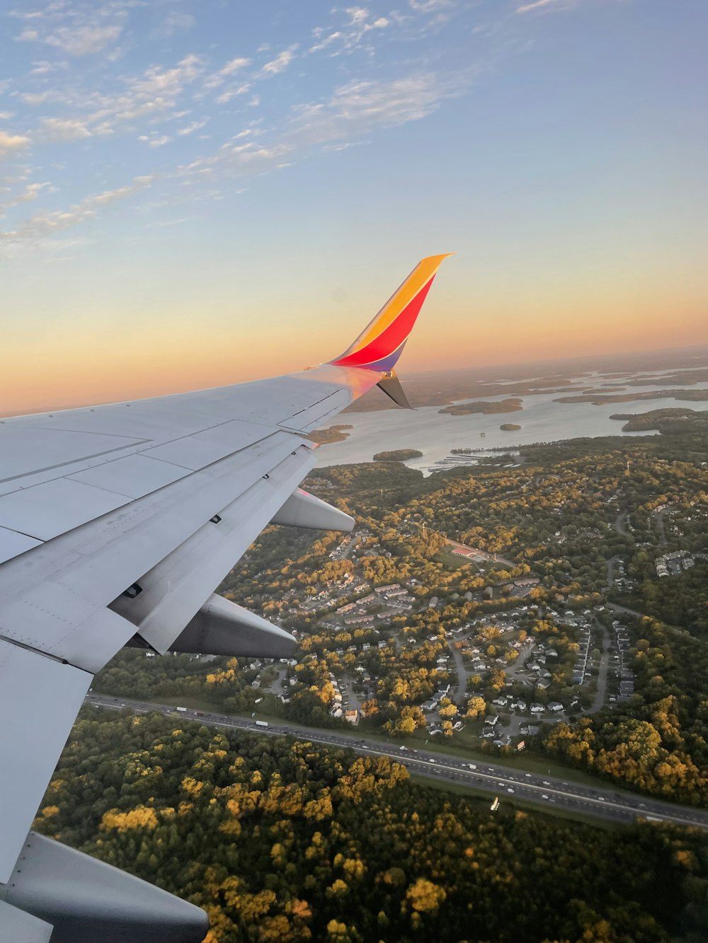 the wing of an airplane as it flies over a city