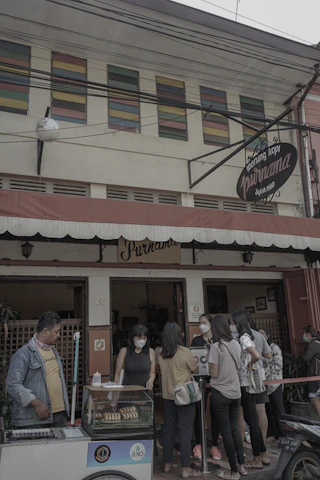 Cheerful customers enjoying traditional Indonesian snacks in a warm, inviting restaurant setting.