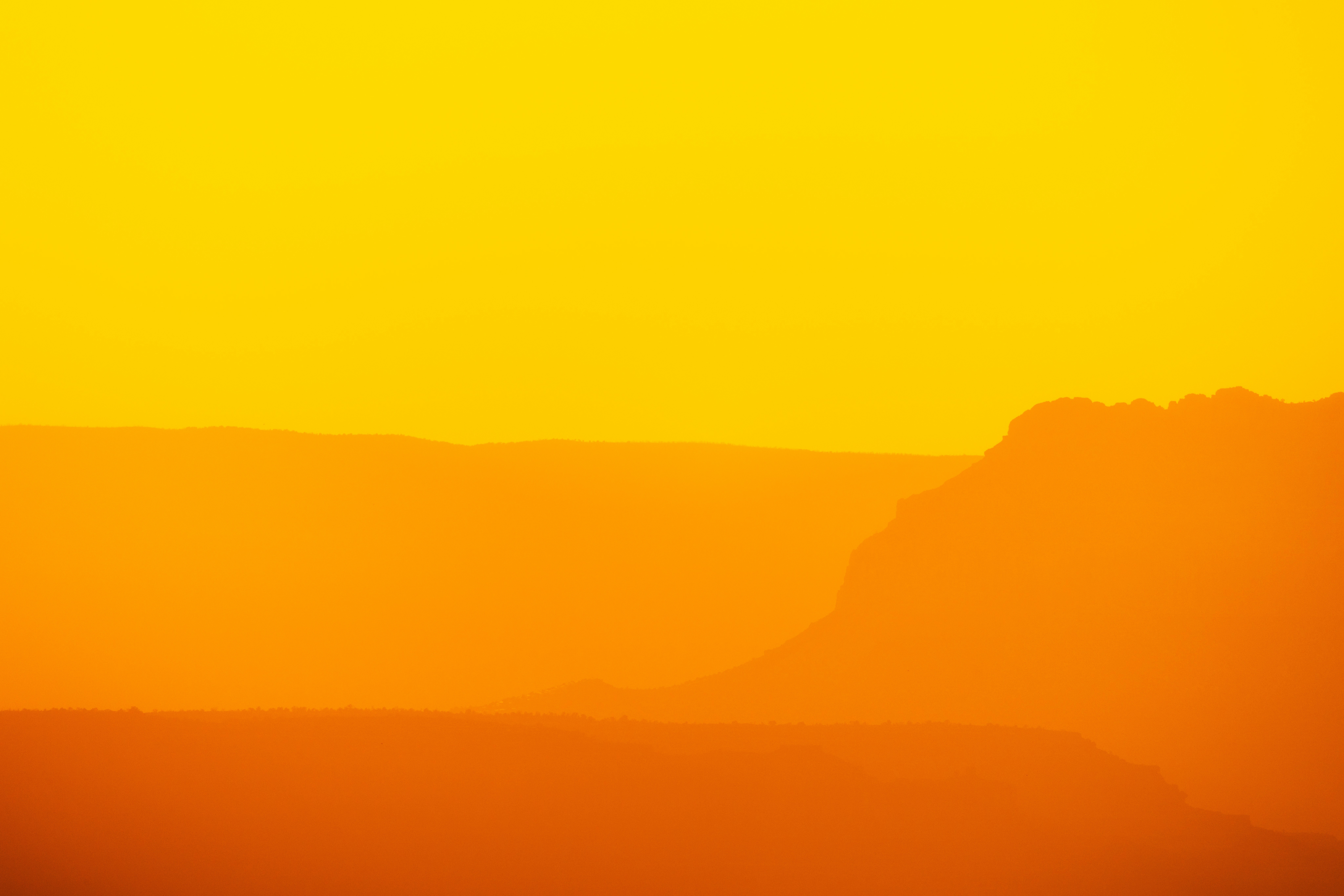 a plane flying over a mountain range at sunset