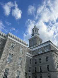 A calm sunrise over a solid stone building symbolizing stability.