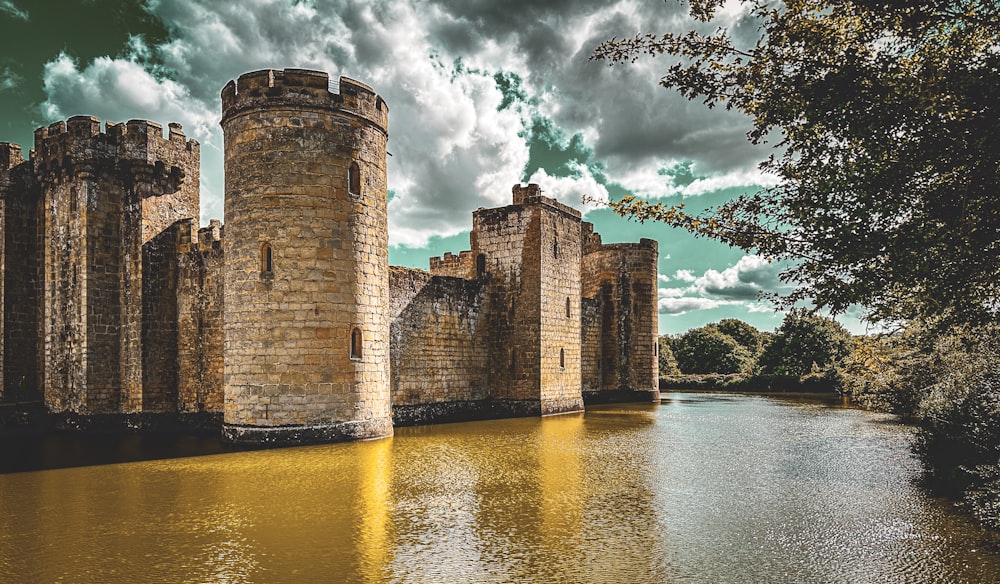 a castle sitting on top of a river next to a forest