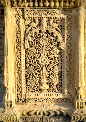 Close-up of an intricately carved wooden panel featuring traditional Persian patterns.