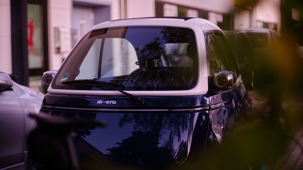 a small blue car parked on the side of the road