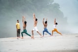a group of people doing yoga on a beach