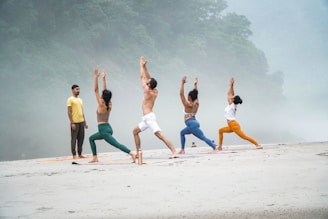 a group of people doing yoga on a beach
