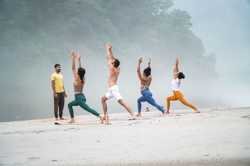 a group of people doing yoga on a beach