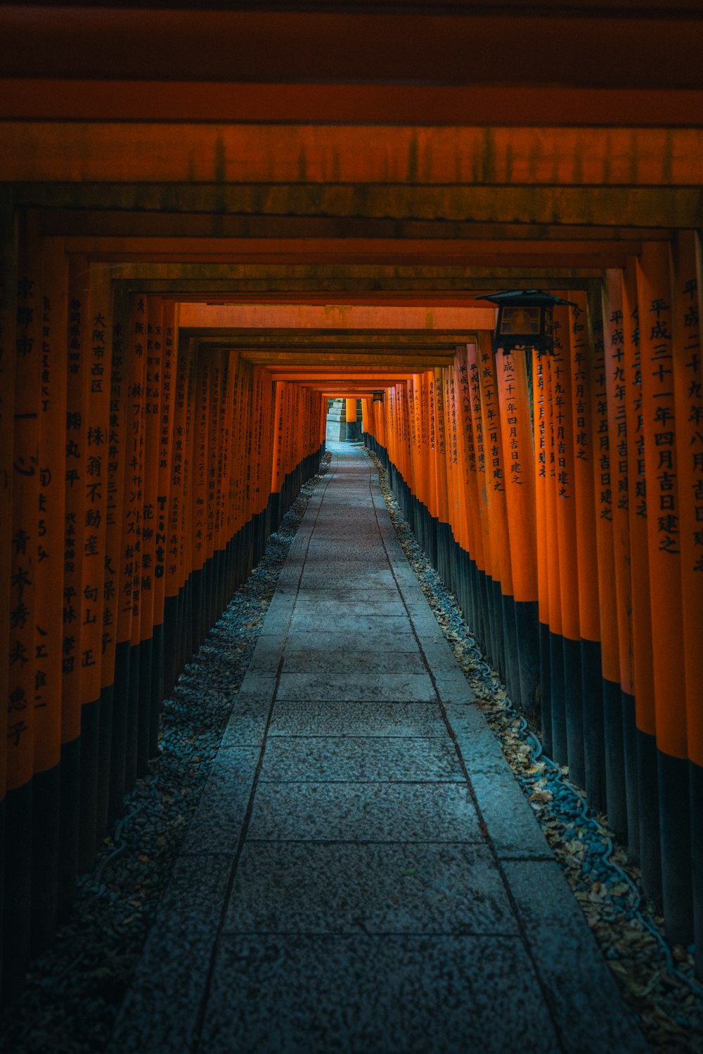 a walkway lined with orange and black columns