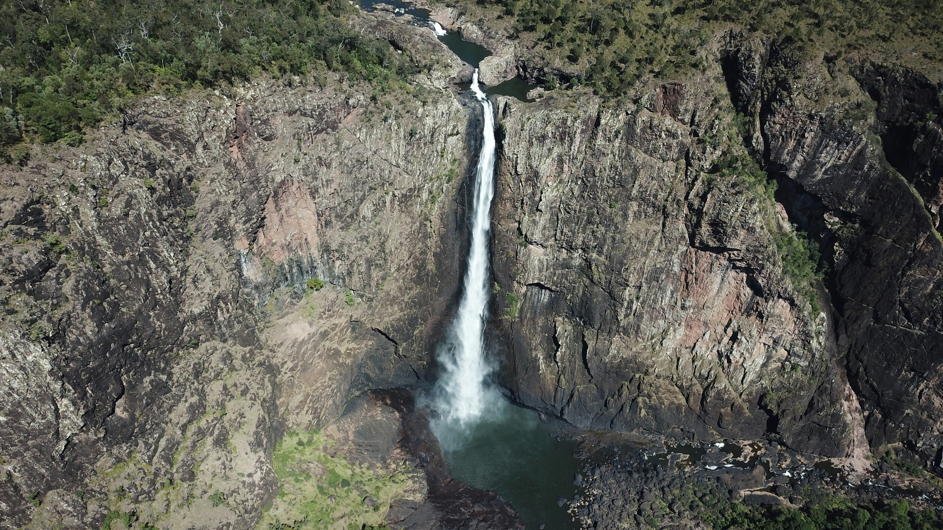 an aerial view of a waterfall in the mountains
