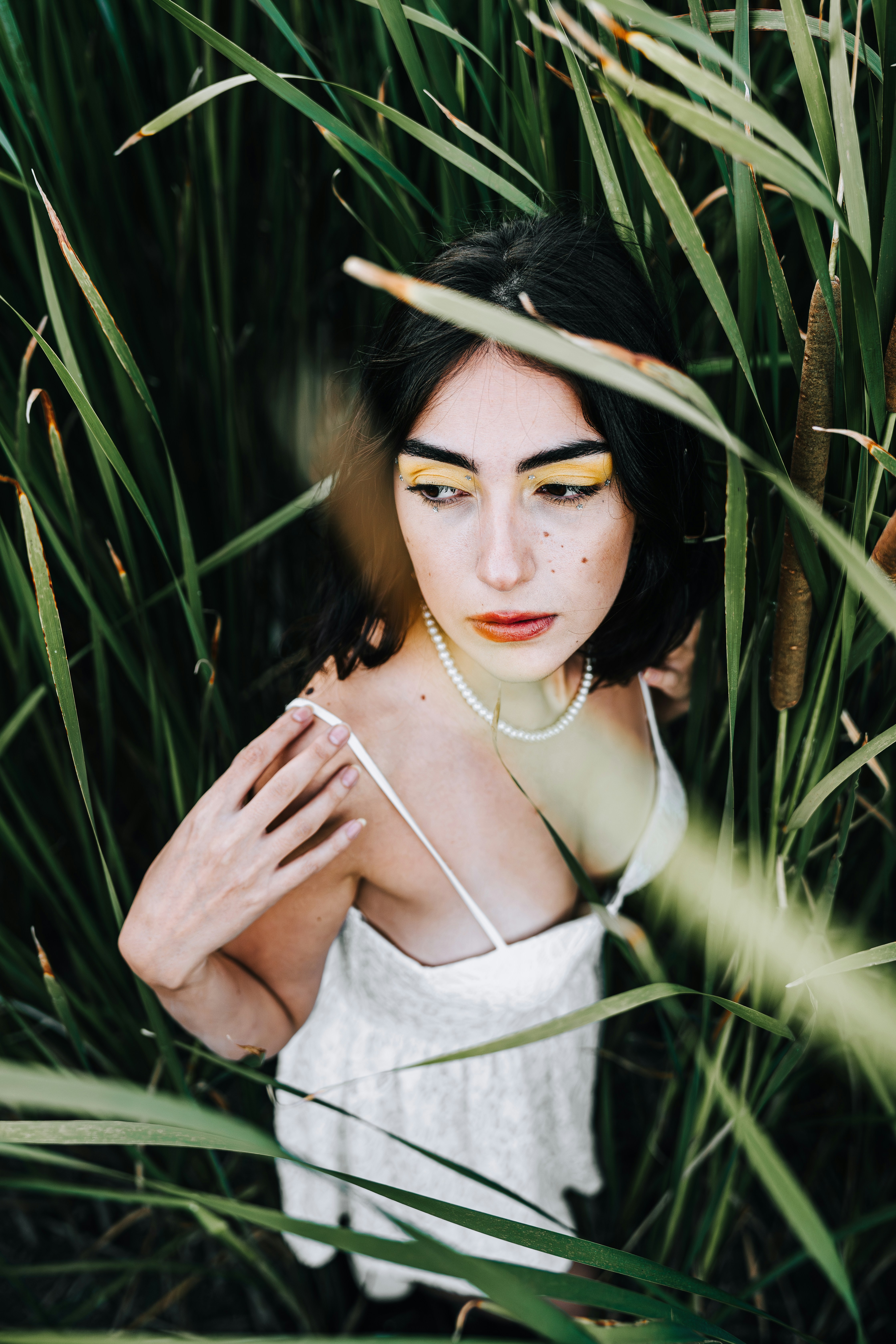 a woman in a white dress standing in tall grass