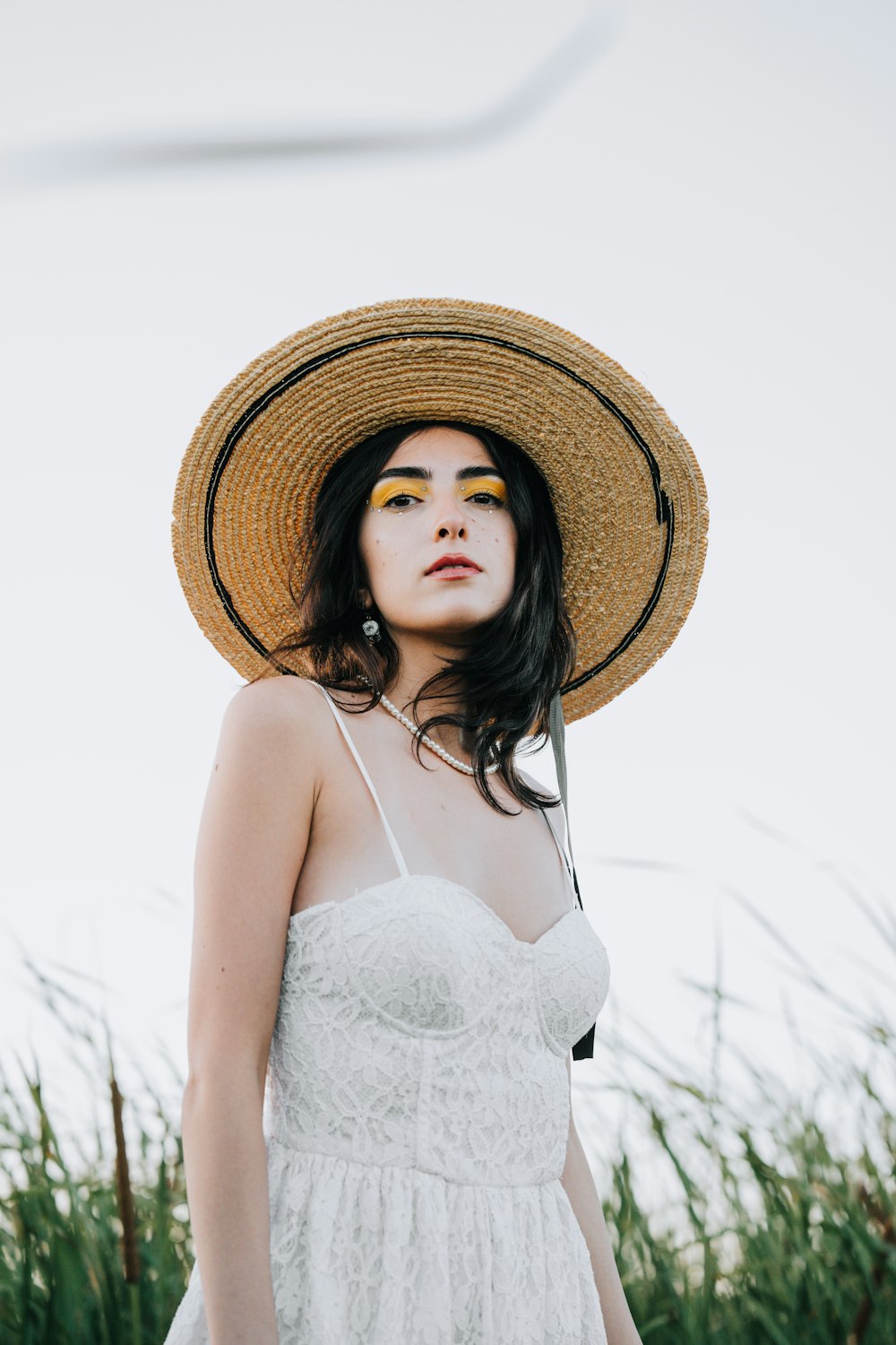 a woman wearing a straw hat and a white dress